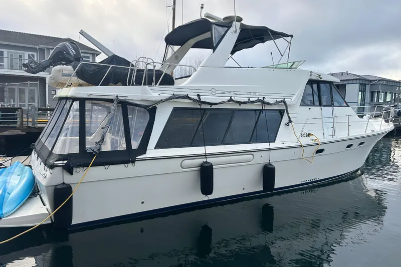 Slide: The Image of 1999 Bayliner 4788 Pilot House Motoryacht docked at marina, side view. - 1