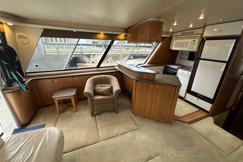 Slide: The Image of Luxurious interior of 1999 Bayliner 4788 Pilot House Motoryacht with modern kitchen and seating area. - 12
