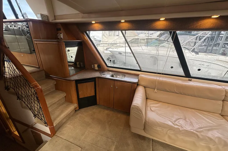 Slide: The Image of Interior of 1999 Bayliner 4788 Pilot House Motoryacht with sofa, kitchenette, and stairs. - 16