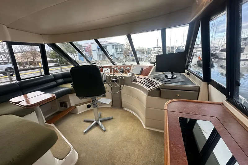 Slide: The Image of 1999 Bayliner 4788 Pilot House Motoryacht interior with helm, seating, and panoramic windows. - 18