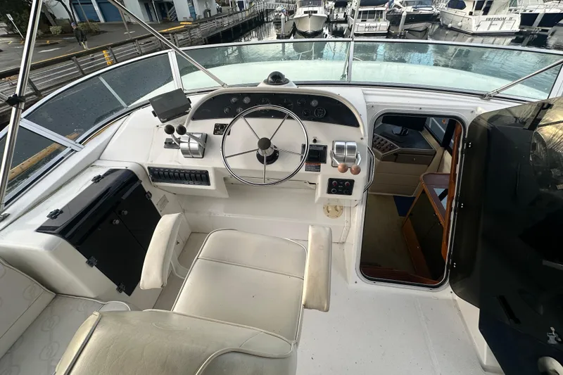 Slide: The Image of 1999 Bayliner 4788 Pilot House Motoryacht helm with steering wheel and control panel. - 28