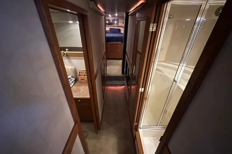 Slide: The Image of 1999 Bayliner 4788 Pilot House Motoryacht interior hallway with wood accents and modern amenities. - 32