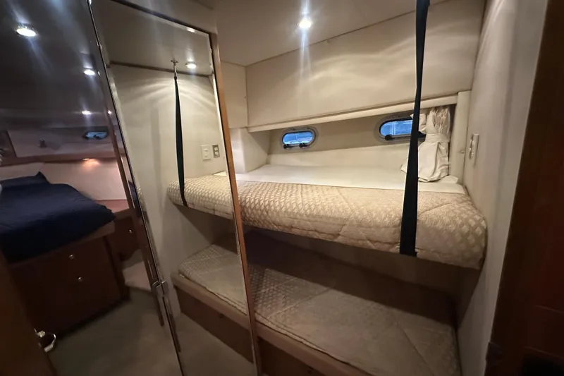 Slide: The Image of 1999 Bayliner 4788 Pilot House Motoryacht interior with cozy bunk beds and porthole windows. - 34