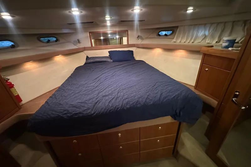 Slide: The Image of Luxurious bedroom in 1999 Bayliner 4788 Pilot House Motoryacht with cozy bedding and wooden cabinetry. - 36