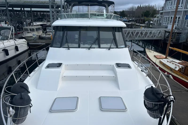 Slide: The Image of 1999 Bayliner 4788 Pilot House Motoryacht docked at marina, showcasing sleek design. - 7