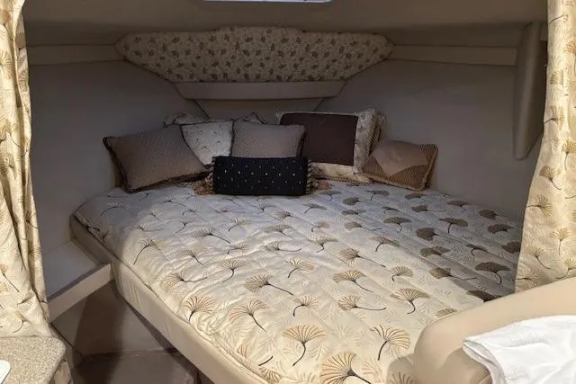 Slide: The Image of Cozy cabin interior of 2000 Formula 31 Performance Cruiser with patterned bedding and pillows. - 13