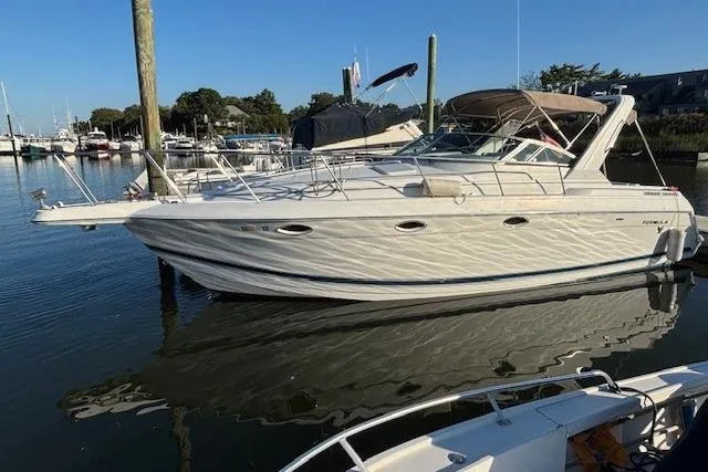 Slide: The Image of 2000 Formula 31 Performance Cruiser docked in a marina under clear blue skies. - 3