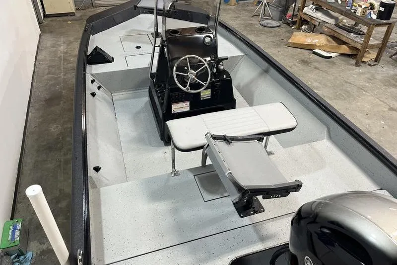 Slide: The Image of 2025 SeaArk Shadow 187T boat interior with steering console and seating in a garage setting. - 4