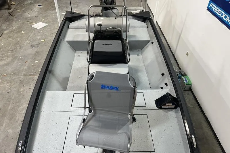 Slide: The Image of 2025 SeaArk Shadow 187T boat interior with seating and console in a showroom. - 5