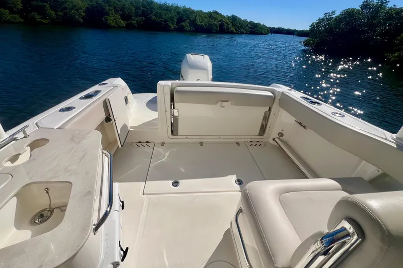 Slide: The Image of 2018 Boston Whaler 230 Vantage boat interior with seating, on a sunny day by the water. - 11