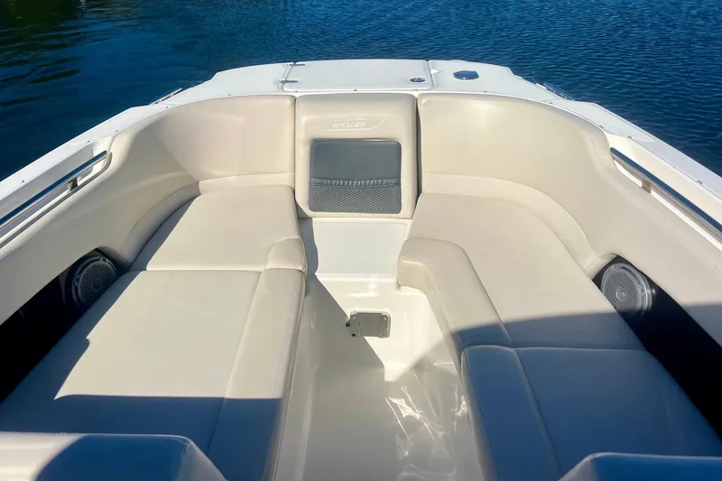 Slide: The Image of 2018 Boston Whaler 230 Vantage boat interior with cushioned seating and water view. - 12