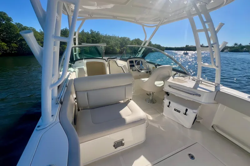 Slide: The Image of 2018 Boston Whaler 230 Vantage boat interior with seating and helm, on a sunny day. - 7