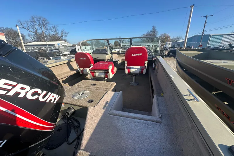 Slide: The Image of 2006 Lowe Fish & Ski 175 boat interior with Mercury engine, red seats, and spacious layout. - 9