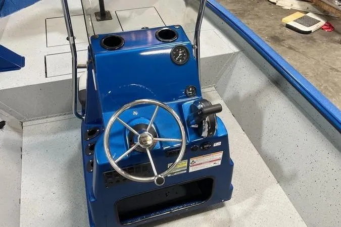 Slide: The Image of 2025 SeaArk Shadow 187T boat console with blue steering wheel and controls. - 8