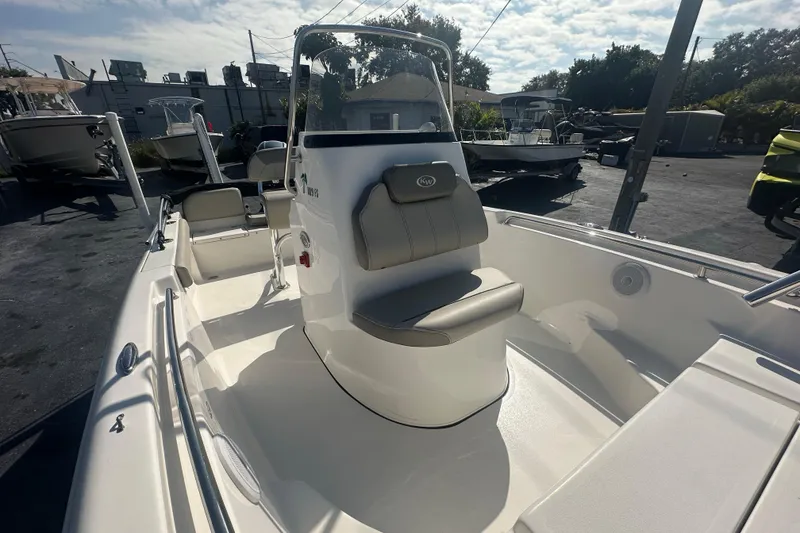 Slide: The Image of 2024 Key West 189 FS boat interior with seating and console, parked outdoors. - 12