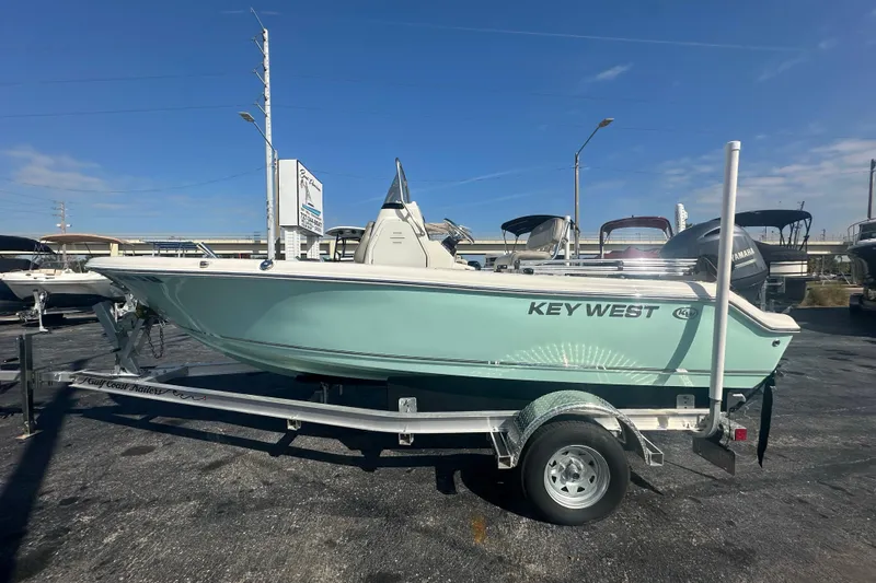 Slide: The Image of 2024 Key West 189 FS boat on trailer, displayed outdoors under clear blue sky. - 2