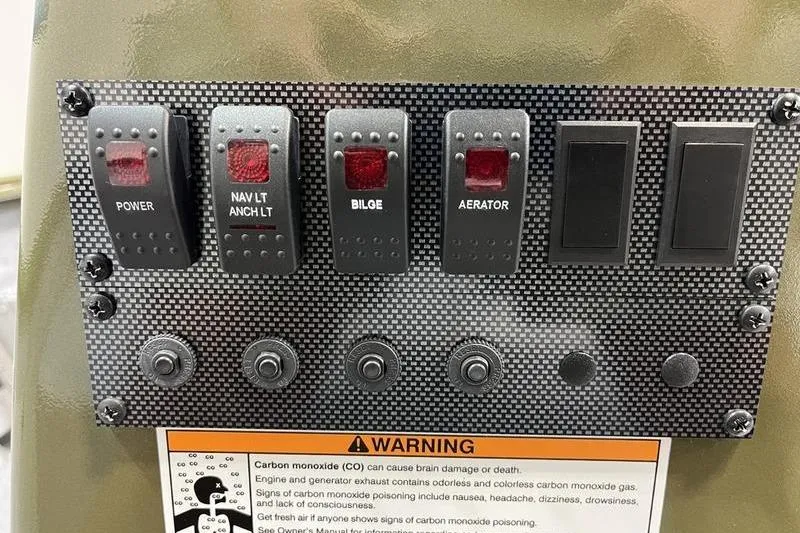 Slide: The Image of Control panel of 2025 SeaArk Shadow 187J boat with switches and warning label. - 9