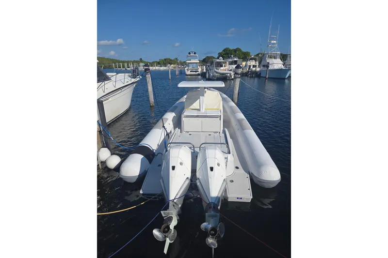 Slide: The Image of 2013 Zeta Elle 34 Custom boat docked in marina, featuring dual outboard motors. - 1