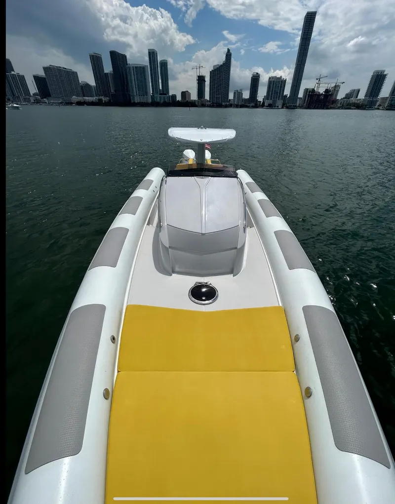 Slide: The Image of Zeta Elle 34 Custom 2013 boat with yellow seating, city skyline in background. - 13