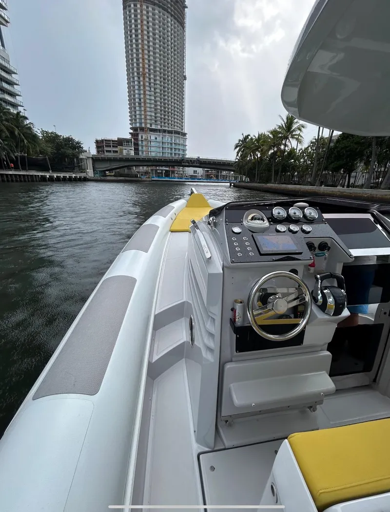 Slide: The Image of 2013 Zeta Elle 34 Custom boat cruising in urban waterway with skyscraper view. - 15