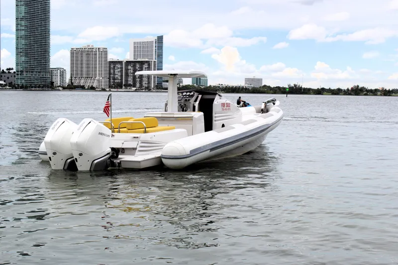 Slide: The Image of 2013 Zeta Elle 34 Custom boat on water with city skyline in background. - 2