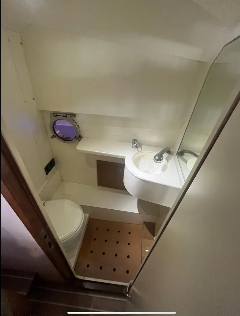 Slide: The Image of 2013 Zeta Elle 34 Custom yacht bathroom with toilet, sink, and porthole window. - 24