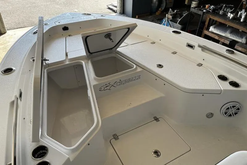 Slide: The Image of 2025 Crevalle 26 HCO boat interior with storage compartments and logo. - 14