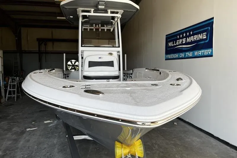 Slide: The Image of 2025 Crevalle 26 HCO boat in showroom, Miller's Marine sign visible. - 2