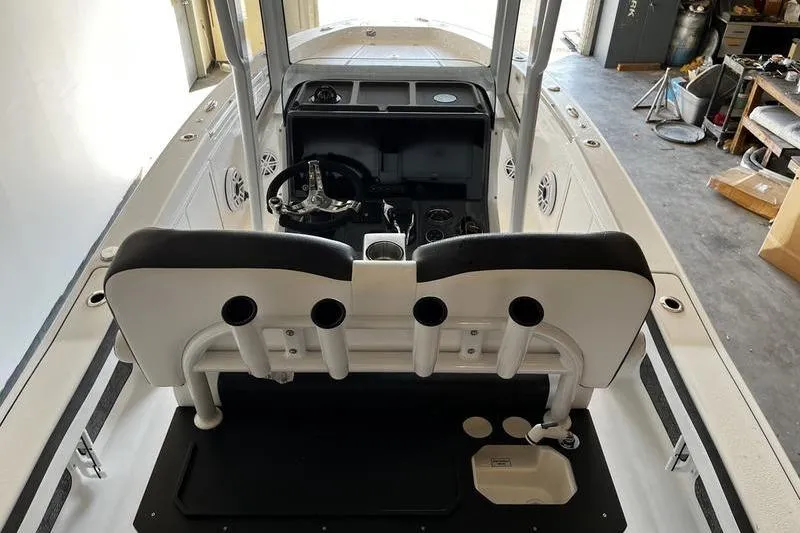 Slide: The Image of 2025 Crevalle 26 HCO boat interior with steering console and rod holders. - 7