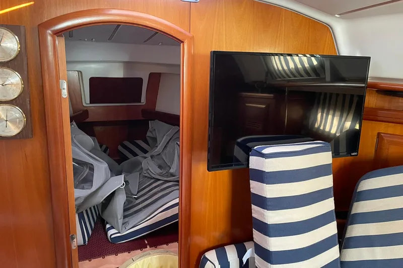 Slide: The Image of Interior of 2001 Beneteau Oceanis 361 yacht with striped seating and mounted TV. - 36
