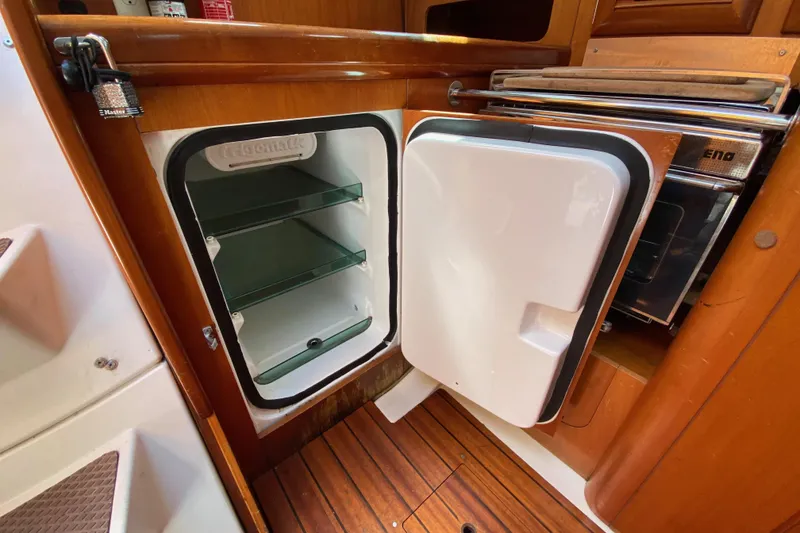 Slide: The Image of Open fridge in 2001 Beneteau Oceanis 361 sailboat kitchen, showcasing interior shelves. - 46