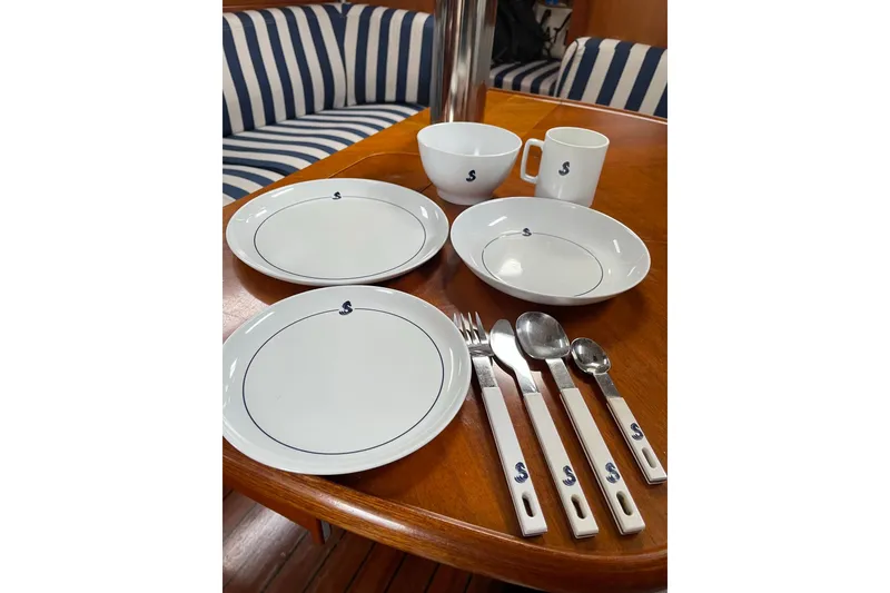 Slide: The Image of Dining set on Beneteau Oceanis 361 yacht, featuring plates, cups, and cutlery. - 62