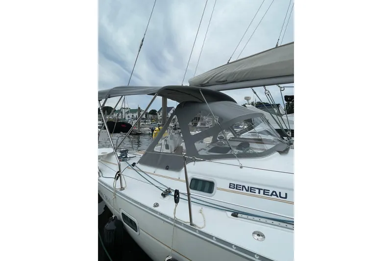 Slide: The Image of 2001 Beneteau Oceanis 361 sailboat docked, featuring a sleek design and protective canopy. - 67