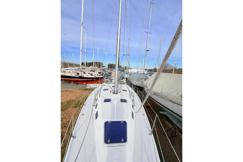 Slide: The Image of 2001 Catalina 380 sailboat docked among other boats under a clear blue sky. - 12