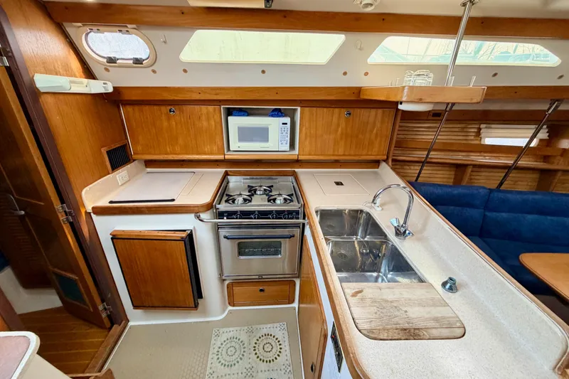 Slide: The Image of 2001 Catalina 380 yacht kitchen with stove, microwave, and dual sink. - 22