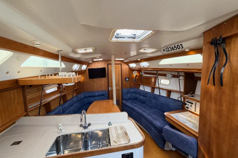 Slide: The Image of Interior of a 2001 Catalina 380 sailboat with cozy seating and wooden finishes. - 23