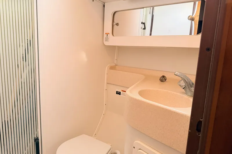 Slide: The Image of Compact bathroom in a 2001 Catalina 380 sailboat, featuring a sink and toilet. - 34