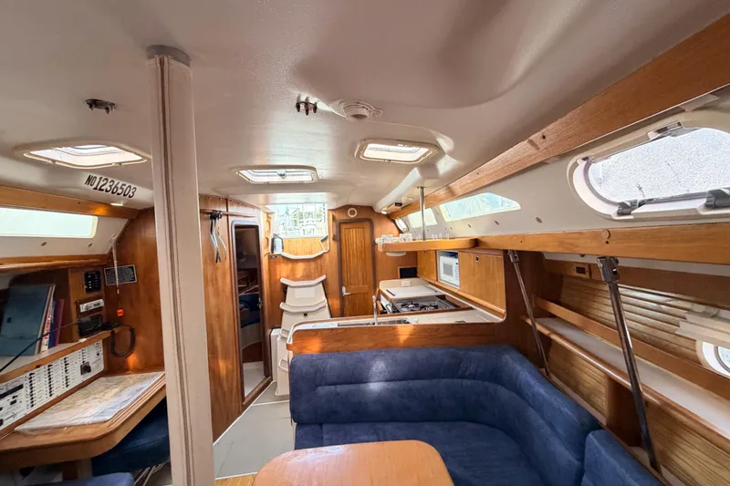 Slide: The Image of Interior of 2001 Catalina 380 sailboat with cozy seating and wooden cabinetry. - 35