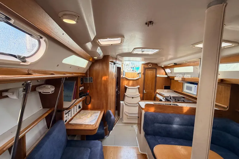 Slide: The Image of Interior of a 2001 Catalina 380 sailboat, featuring a cozy cabin with wood accents. - 36