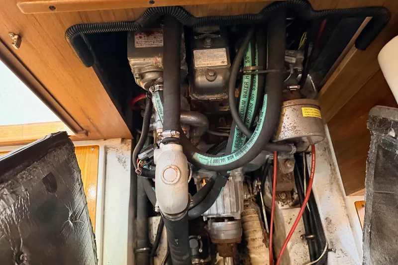 Slide: The Image of Engine compartment of a 2001 Catalina 380 sailboat, showing hoses and mechanical components. - 46