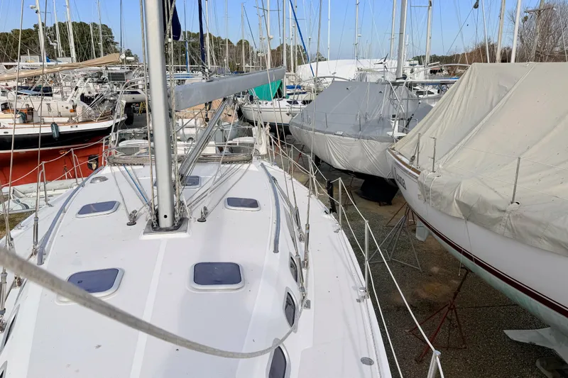Slide: The Image of 2001 Catalina 380 sailboat docked among covered boats in a marina. - 6