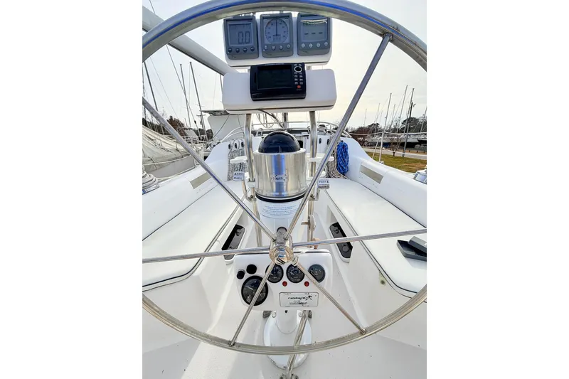 Slide: The Image of Steering wheel and controls of a 2001 Catalina 380 sailboat, featuring navigation instruments. - 7