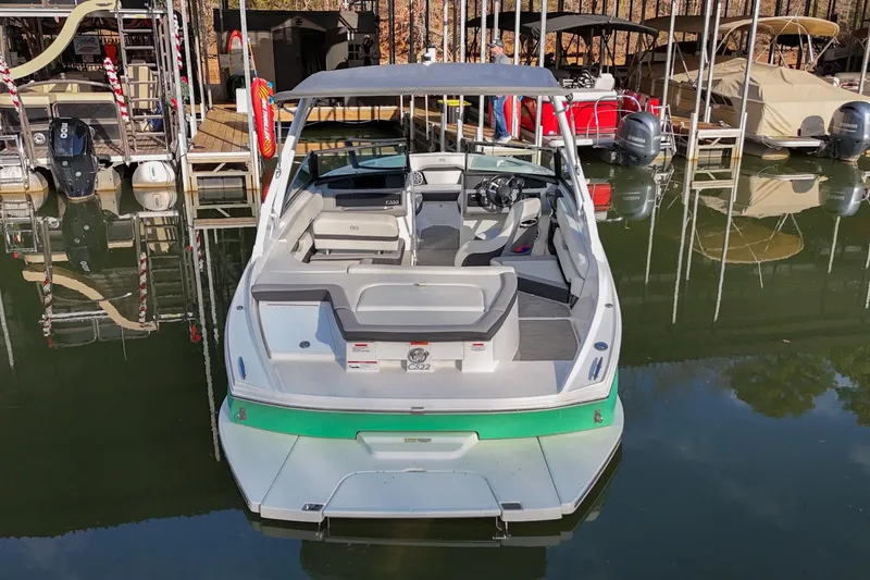 Slide: The Image of 2023 Cobalt CS22 boat docked at marina, featuring sleek design and spacious seating. - 2