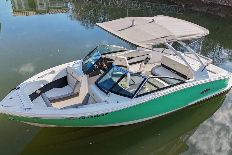 Slide: The Image of 2023 Cobalt CS22 boat with canopy on calm water, featuring sleek design and spacious seating. - 6