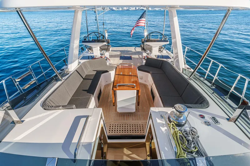 Slide: The Image of Luxurious 2025 Hylas H57 yacht deck with seating, table, and ocean view. - 21
