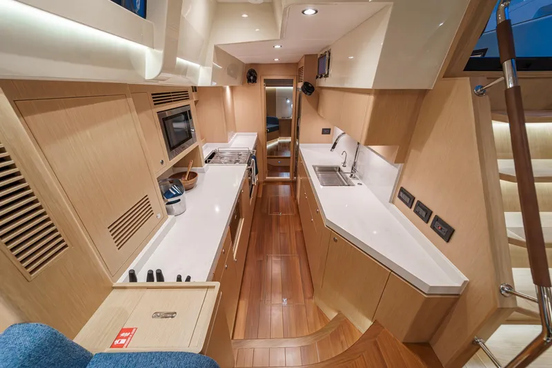 Slide: The Image of Luxurious interior of 2025 Hylas H57 yacht, featuring modern kitchen and sleek wood finishes. - 36