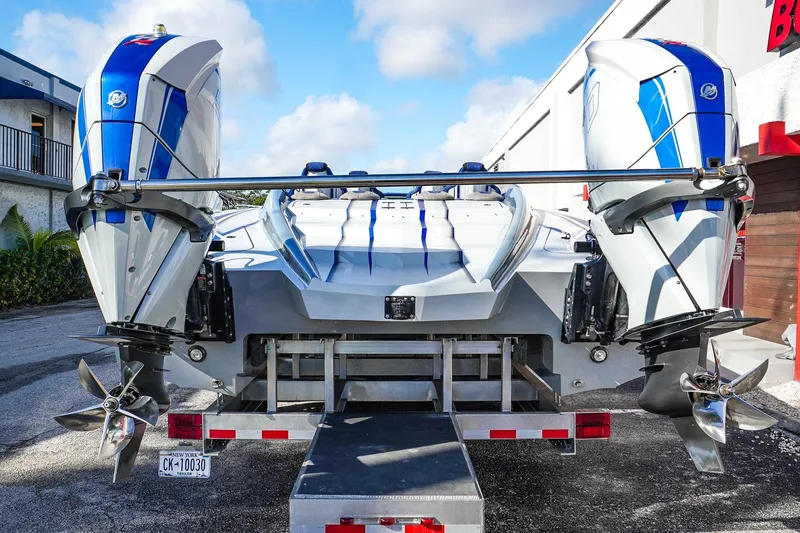 Slide: The Image of 2026 Statement 396 boat with dual outboard motors on a trailer, rear view. - 8