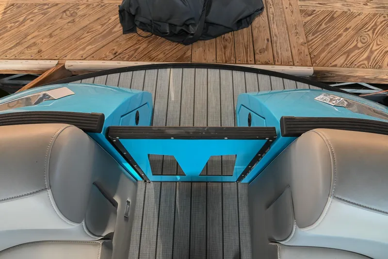 Slide: The Image of Interior view of 2023 Montara 25 Monntara 2.0 boat with blue accents and wooden dock. - 44