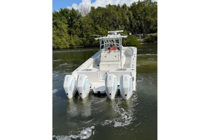 Slide: The Image of 2022 SeaHunter 38 CTS boat with four engines on a calm waterway. - 4