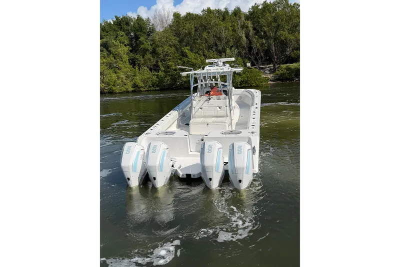 Slide: The Image of 2022 SeaHunter 38 CTS boat with four engines on a calm waterway. - 7